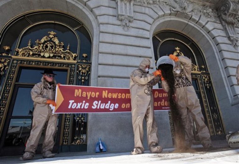 Demonstrators with the Organic Consumers Association pour city-issued compost on the steps of city hall in San Francisco on Thursday.  